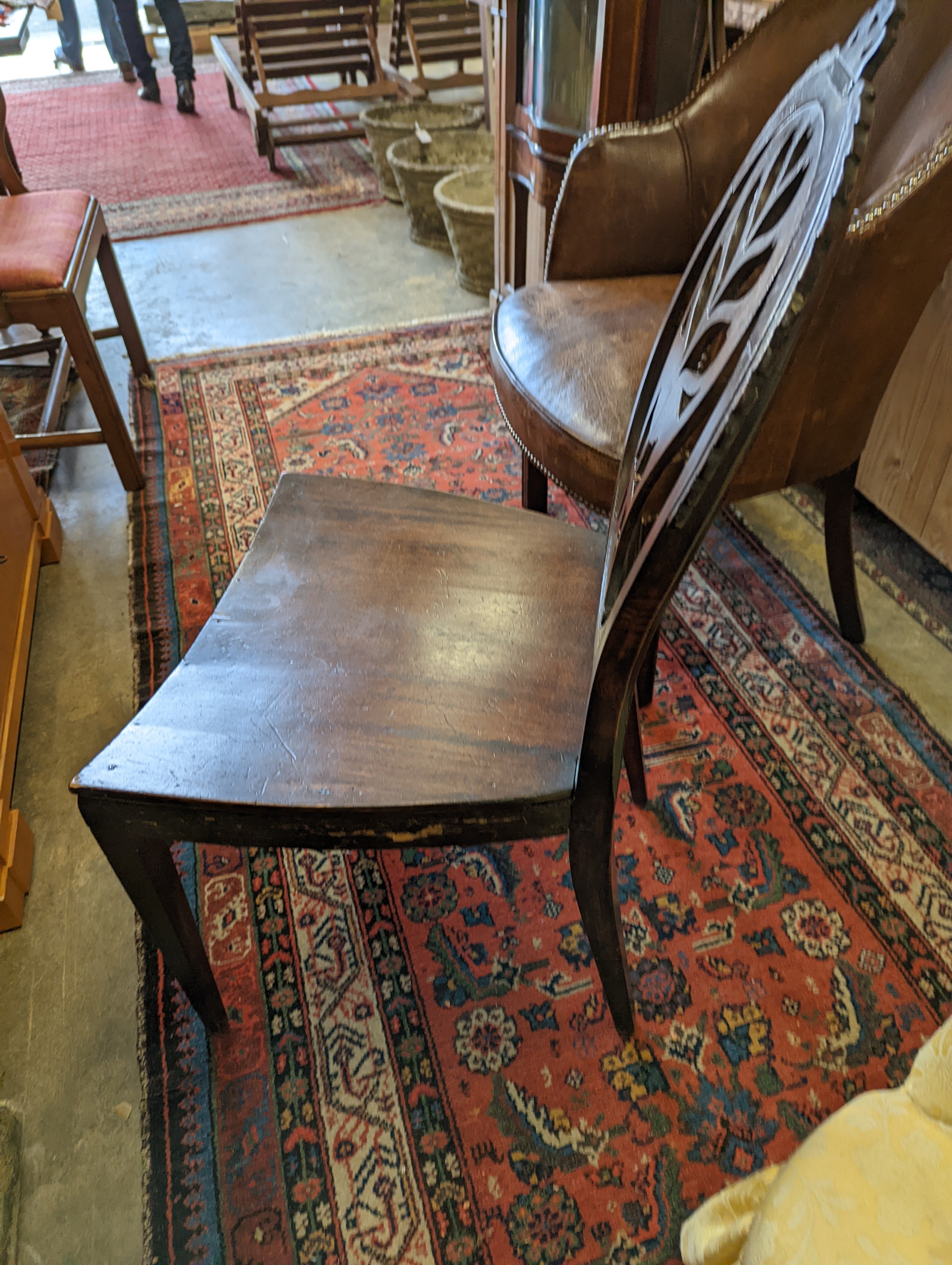 A brown leather upholstered desk chair, a mahogany hall chair and two upholstered armchairs